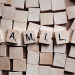 Scrabble pieces that spell FAMILY sitting on top of blank Scrabble pieces