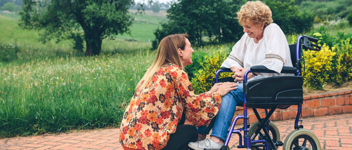 young-woman-talking-to-elderly-woman-in-wheelchair-poster
